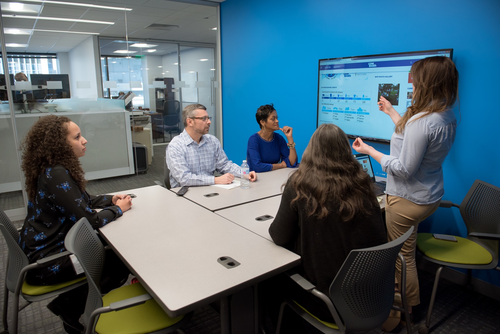 Employees gathered around a conference table and bring diverse perspectives to a meeting.