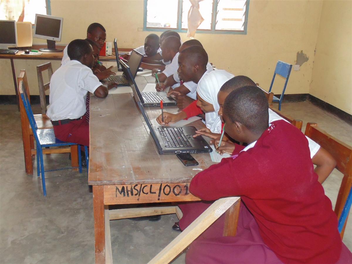 Two CDM Smith employees posing in front of backpacks that were donated for YMCA Operation Backpack