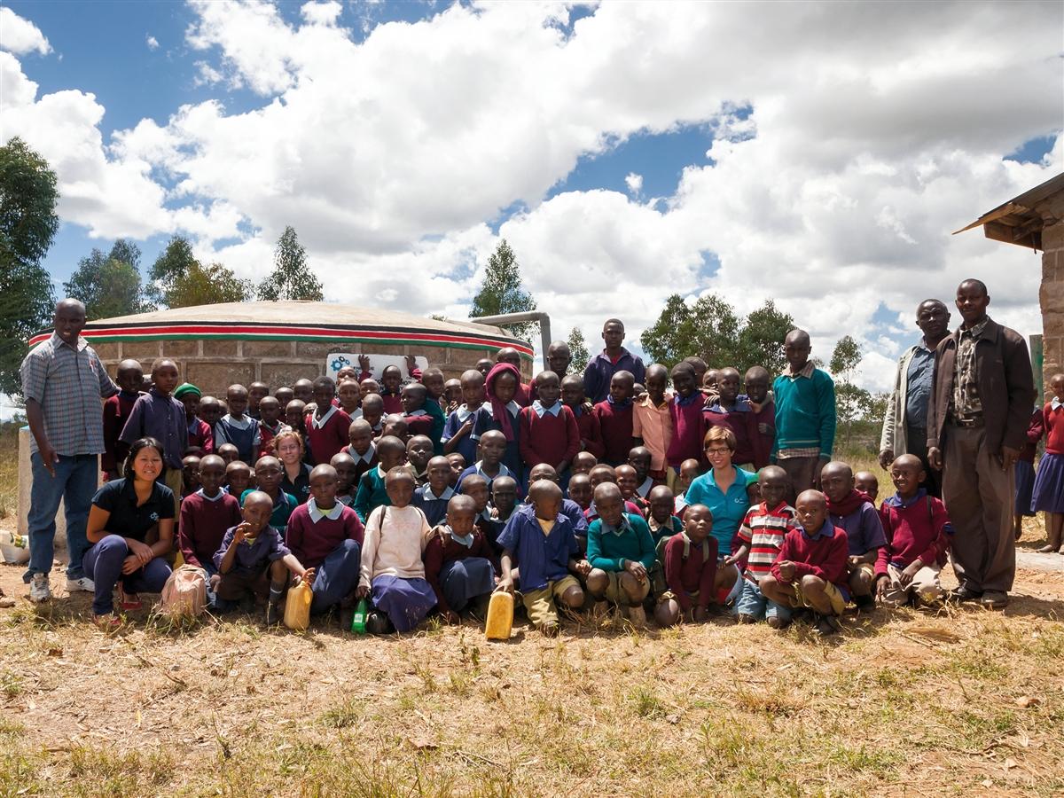 70+ people posing in front of a new rainwater cistern in West Laikipia, Kenya