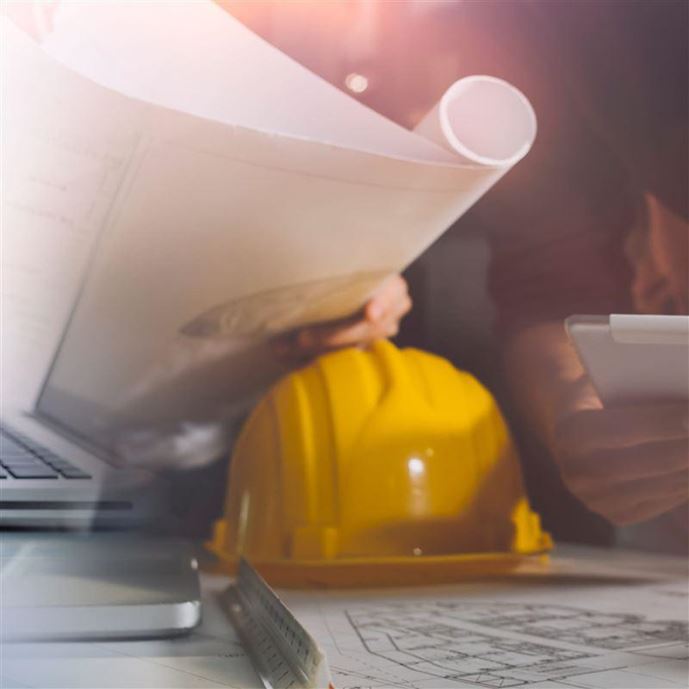 Two colleagues discussing data working and tablet, laptop with on on architectural project at construction site at desk in office