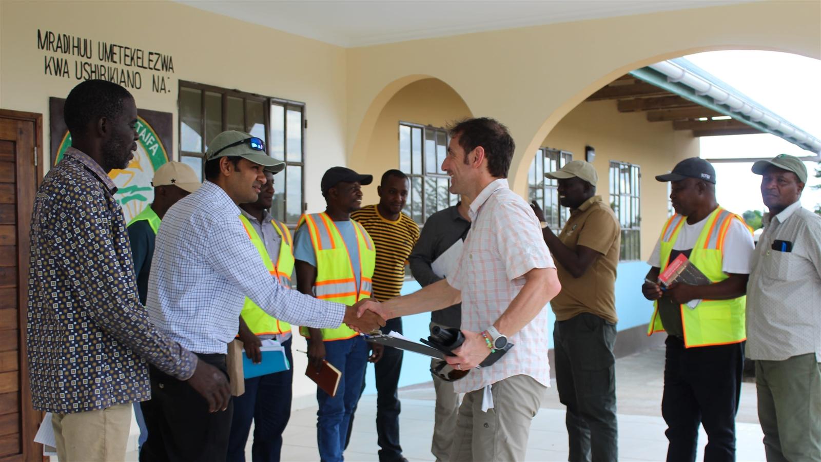 Eine Gruppe von Menschen begrüßt sich gegenseitig mit einem Handschlag