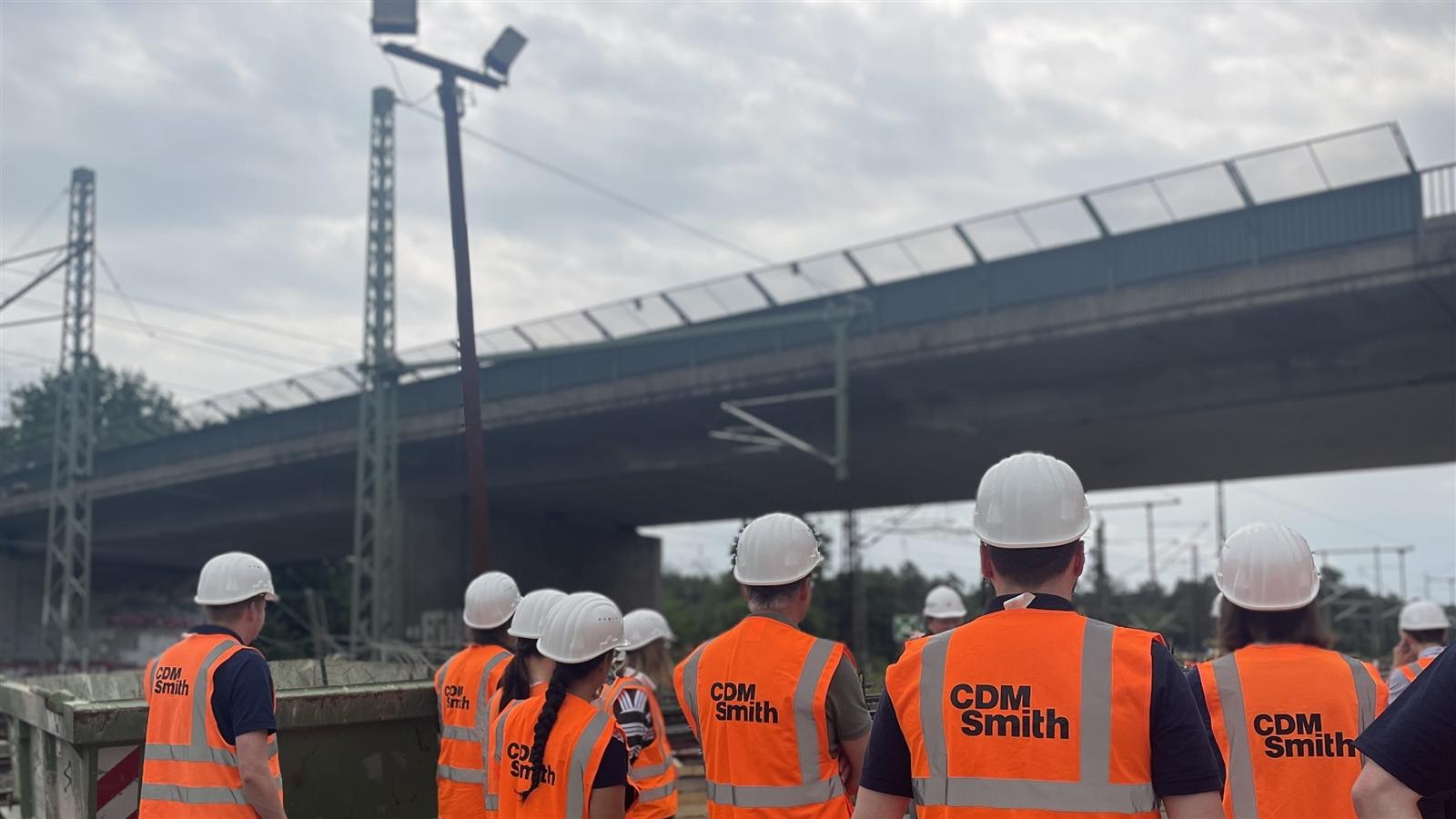 CDM Smith Mitarbeitende beim Baustellenbesuch mit Blick auf eine der Brücken
