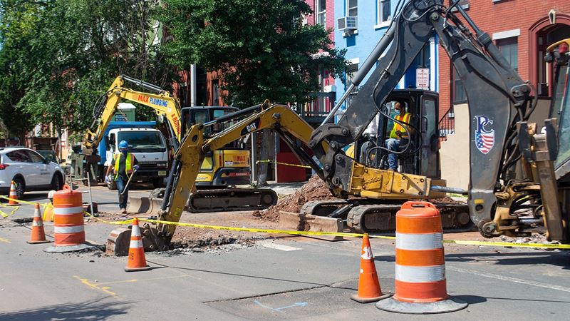 An excavator digs up a street in Newark, NJ as part of the city's lead service line replacement program