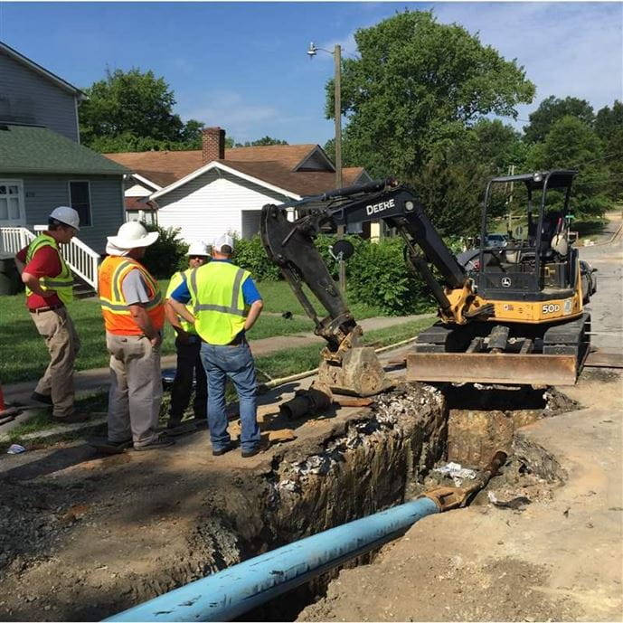 A group of construction workers replacing a pipe